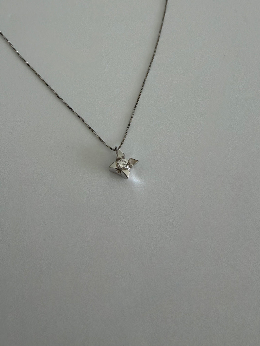 Ciondolo punto luce a stella in oro 18k